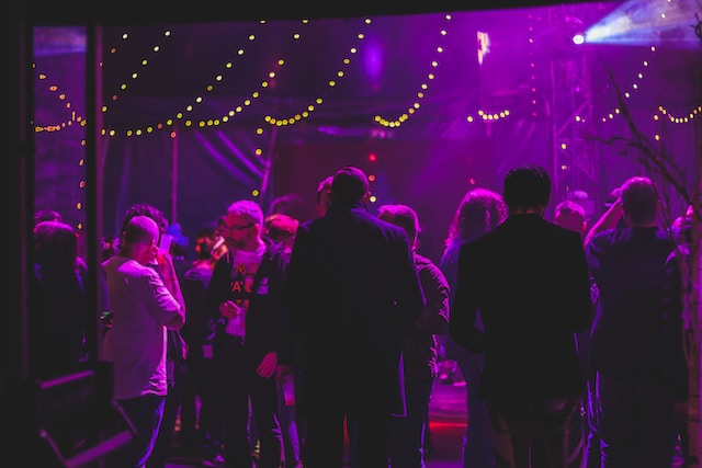 dimly lit party with groups of people talking